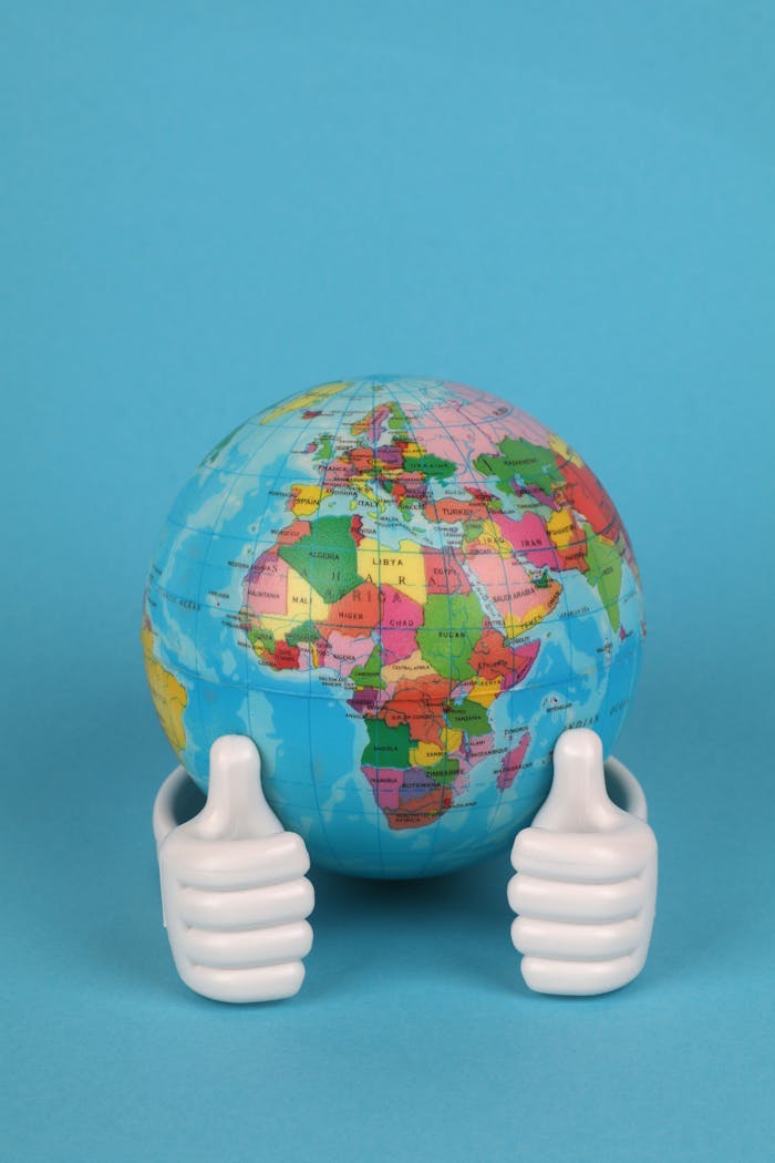 A colorful globe held by two thumbs up hands against a vibrant blue background.